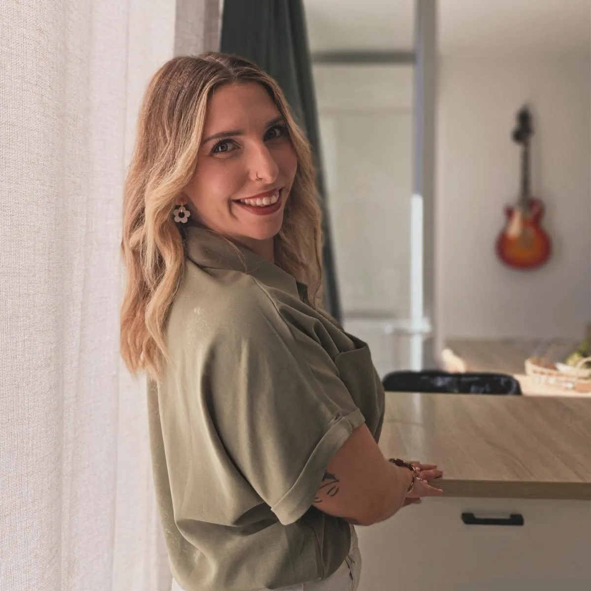 Aude, de Célébrations & Co, souriante dans sa cuisine, en chemise kaki